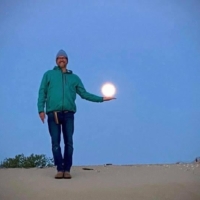 Craig Honeycutt holds the moon in his hand at Jockey's Ridge.